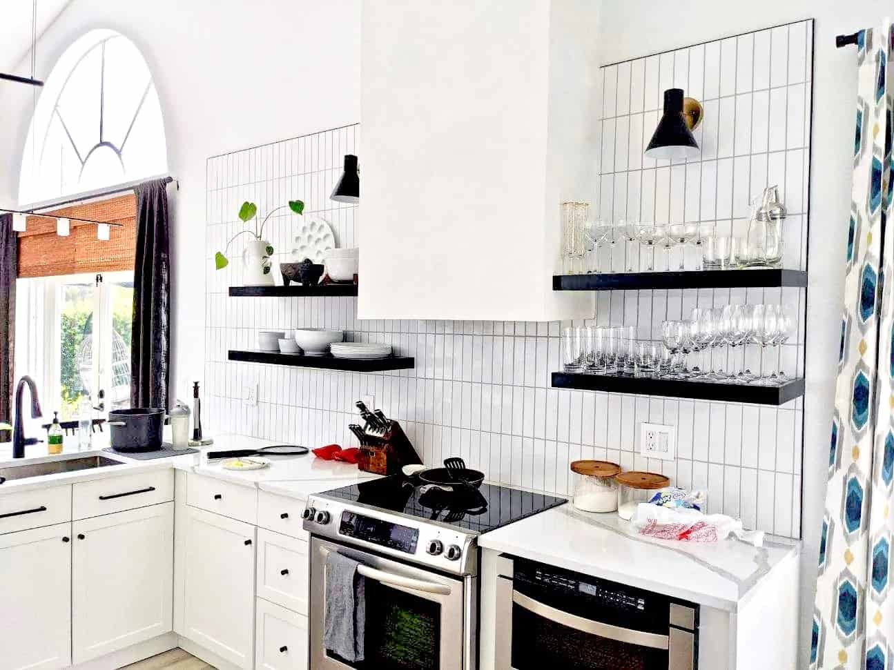 black and white kitchen with the black open shelving